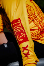 Load image into Gallery viewer, Tide x XXXX fishing jersey in vibrant yellow with red logo, made from recycled materials, UPF 50+ protection.