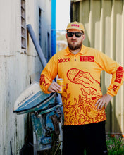 Load image into Gallery viewer, Man wearing Tide x XXXX collab jersey by an outboard motor, promoting reef protection and sustainability.