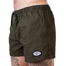 Load image into Gallery viewer, Olive Yabbies shorts for men with zip pockets, perfect for outdoor activities and casual outings, showcasing a tattooed model.